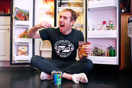 Leo chows down in front of his fridge.