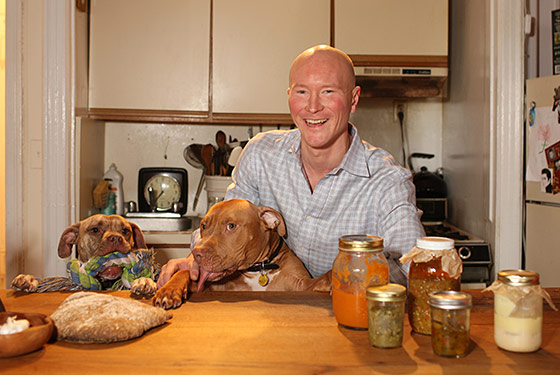 Writer Ian Knauer (and his dogs) in the kitchen.