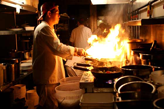 The head chef works on seven woks simultaneously. 